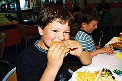 Ein Junge beißt in einen Hamburger